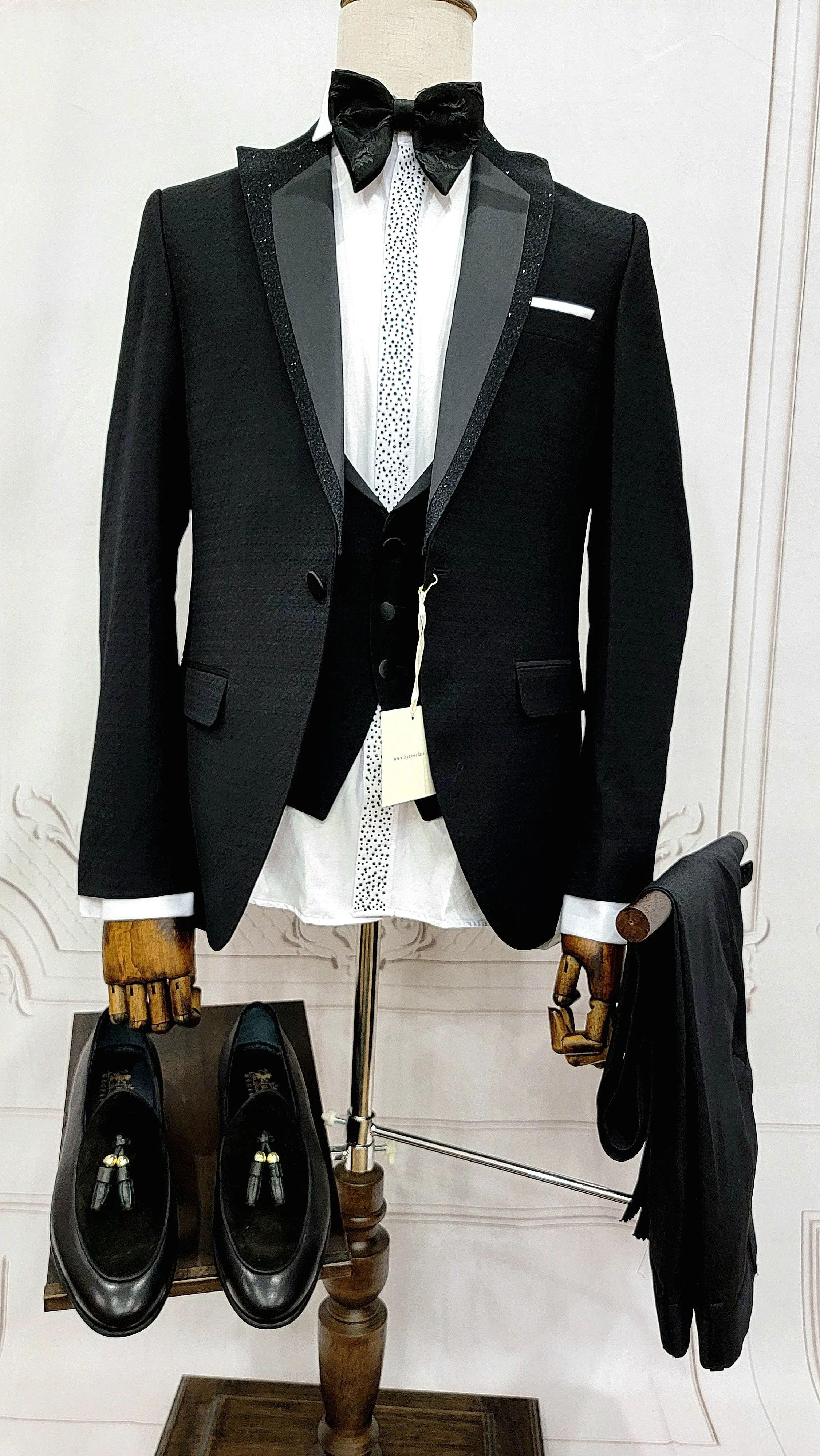 Single Button Three Pieces Tuxedo Suit with Black satin Lapel, matching bow tie and black dress pants.
