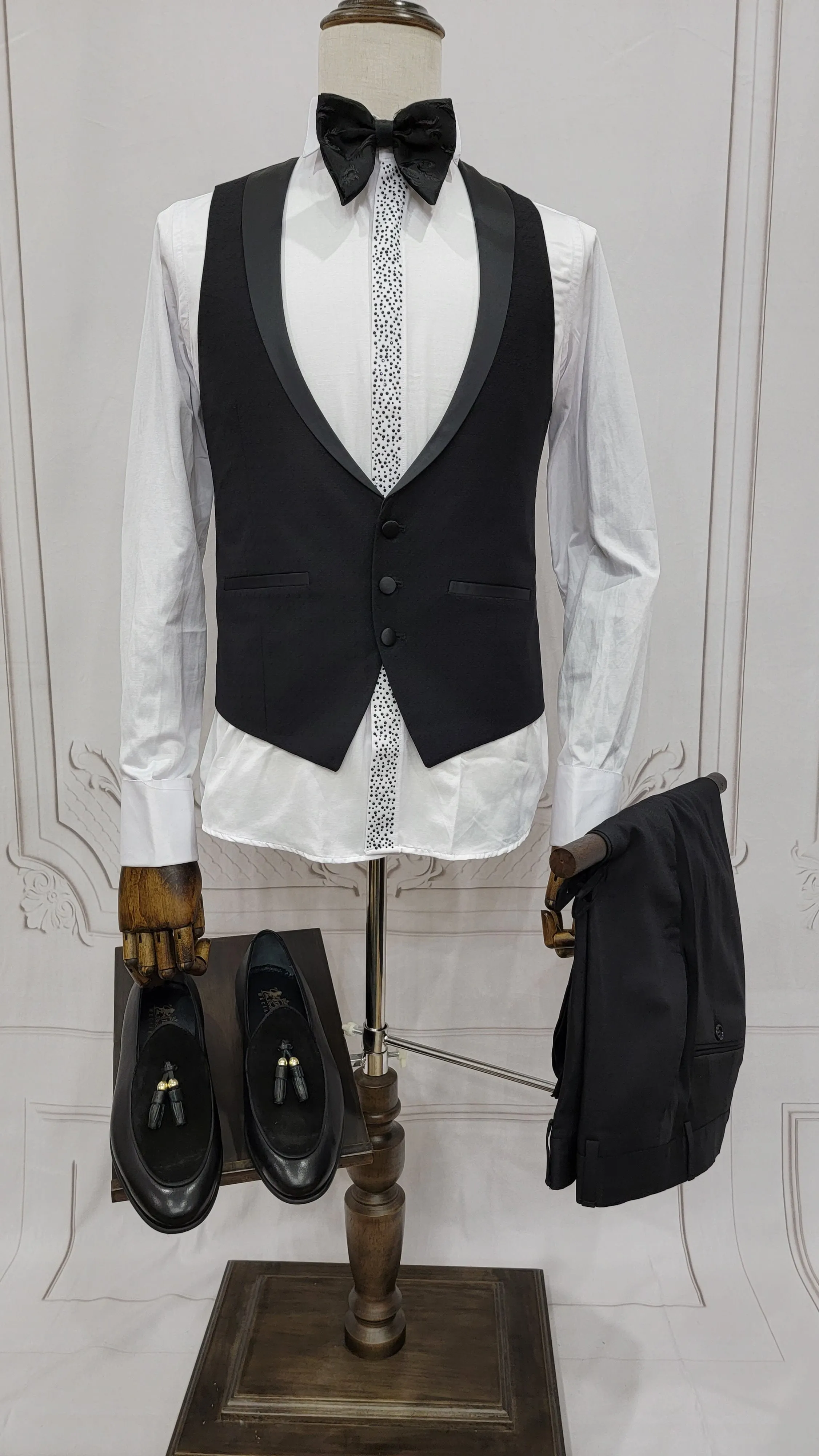 Single Button Three Pieces Tuxedo Suit with Black satin Lapel, matching bow tie and black dress pants.