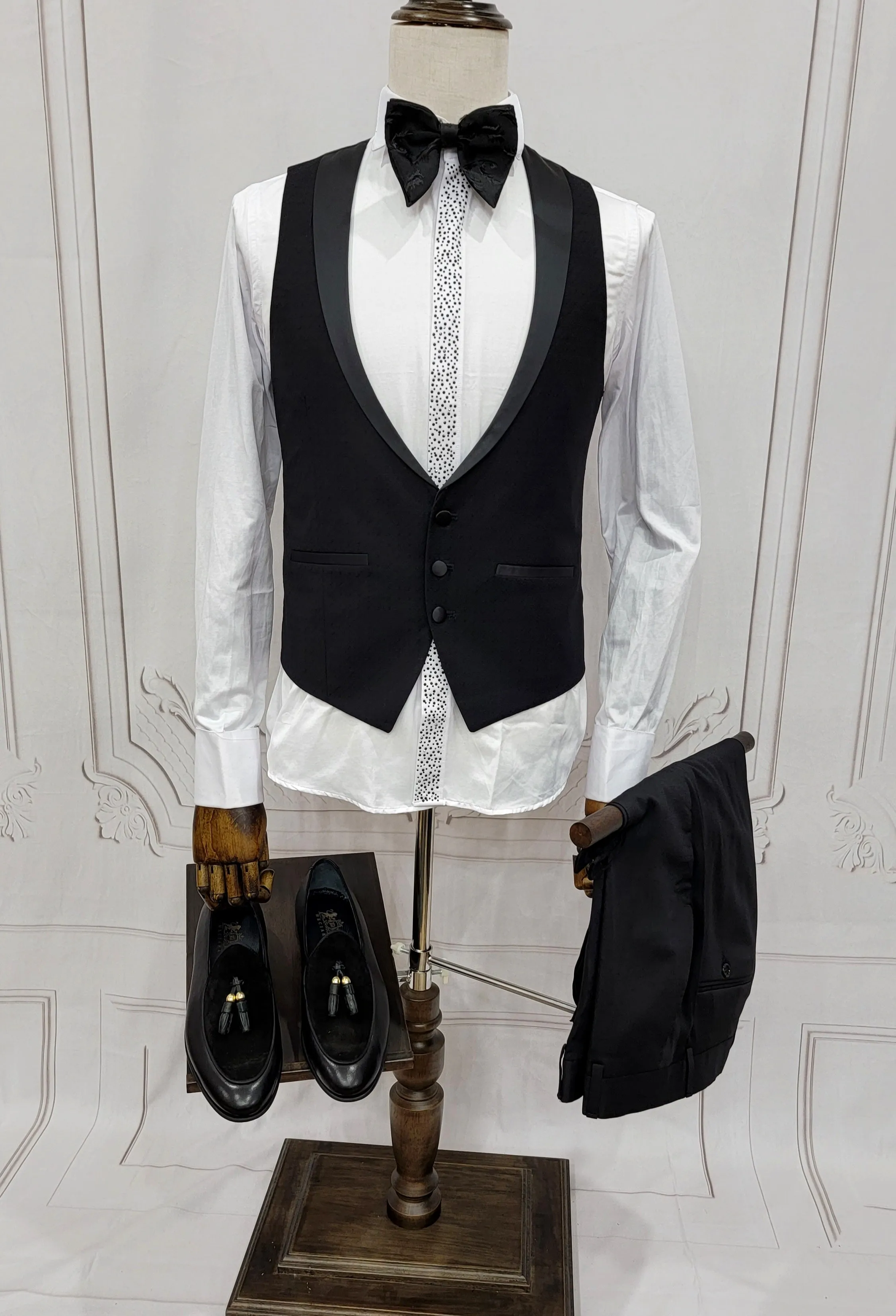 Single Button Three Pieces Tuxedo Suit with Black satin Lapel, matching bow tie and black dress pants.