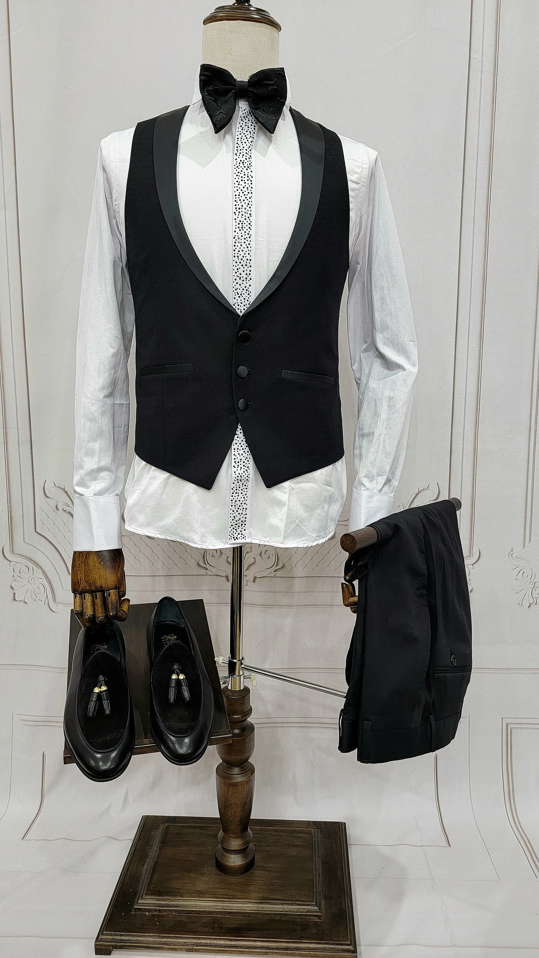 Single Button Three Pieces Tuxedo Suit with Black satin Lapel, matching bow tie and black dress pants.